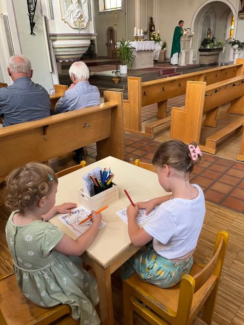 Zwei Kinder sitzen an einem Tisch und malen