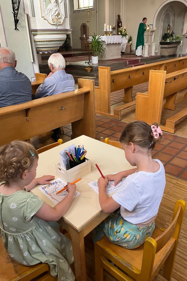 Zwei Kinder sitzen an einem Tisch und malen