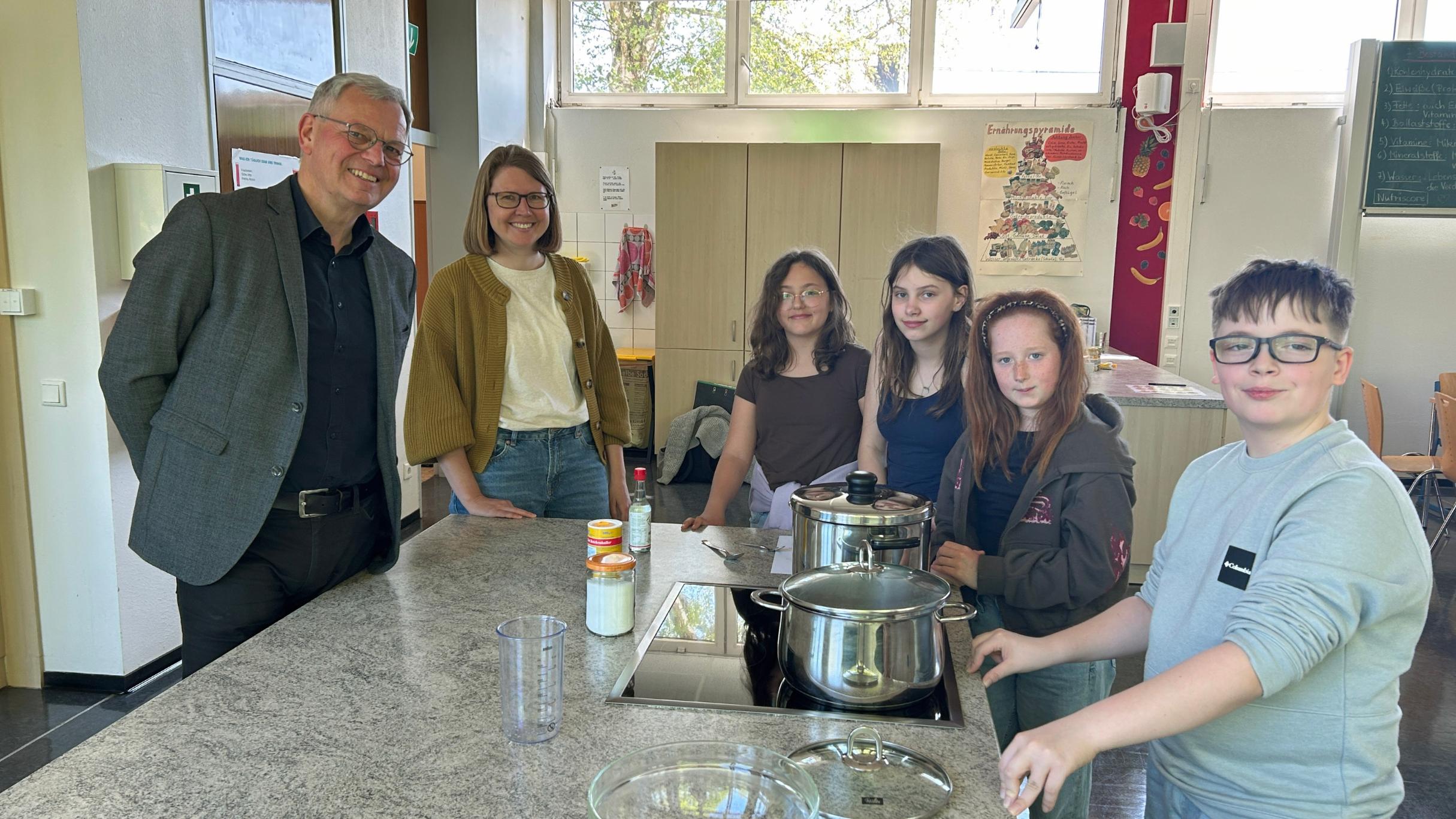 Bischofsvikar Ulrich von Plettenberg, Pastoralreferentin Carina Rui, Vivienne, Vivien, Mailin und Kay kochen den Reis für die Sushi-Bowls.